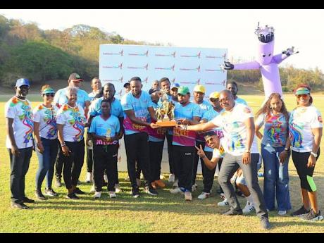 Jamaica Cricket Association CEO Courtney Francis (third right) presents the winning trophy to members of Junction Valley as representatives from Caribbean Airlines look on after the recemt Caribbean Village Cricket series in St Ann.