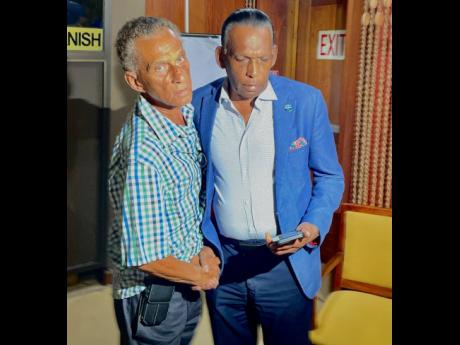 New president of the Jamaica Cricket Association (JCA) Dr Donavan Bennett shakes hands with outgoing president Wilford ‘Billy’ Heaven after the elections of officers at the Jamaica Conference Centre on Thursday.