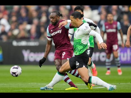 West Ham’s Michail Antonio (left) and Liverpool’s Virgil van Dijk battle for the ball during the English Premier League match at London Stadium, England, on Saturday. The match drew 2-2.