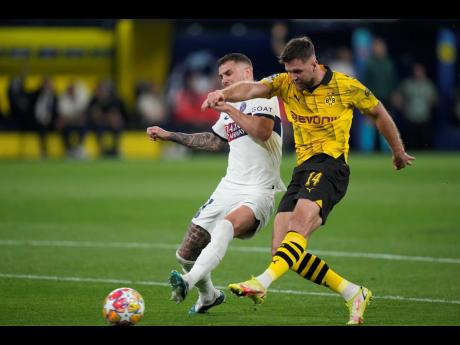 Borussia Dortmund’s Niclas Füllkrug (right) is challenged by Parus Saint-Germain’s Lucas Hernandez during the Champions League semi-final first-leg football match at the Signal-Iduna Park stadium in Dortmund, Germany, yesterday. Dortmund won 1-0.
