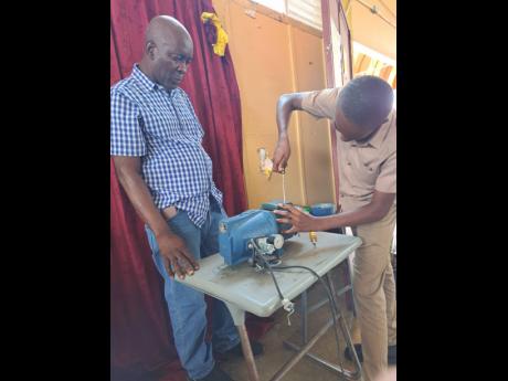Under the watchful eyes of engineer/entrepreneur Frank Sterling, a student dismantles a water pump.