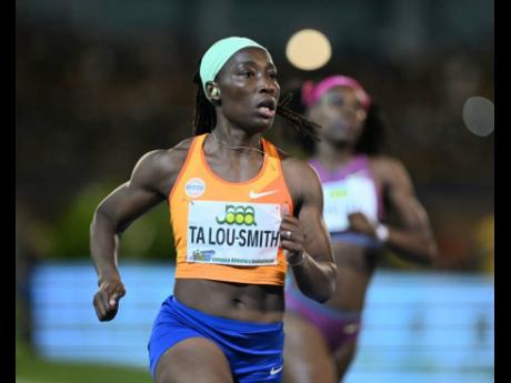 Ivory Coast's Marie-Josée Talou-Smith eases as she wins the women's 100 metres at the Jamaica Athletica Invitational at the National Stadium tonight.
