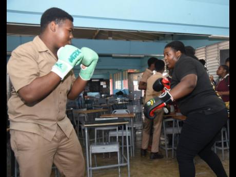 Credit: Ashley Anguin American Boxing Confederation’s woman heavyweight champion of the Caribbean, Jasmine Graham (right), demonstrates boxing techniques to Herbert Morrison Technical High School’s Javier Smith during a Lola Cunningham Foundation boxing workshop programme held at the school in April.