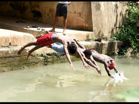 Photos by Ian Allen/Photographer
From left: Nickoy McKnight, Romaine Williams and Jordane Russell dive into the cool waters in Springvale, near Bog Walk, St Catherine.