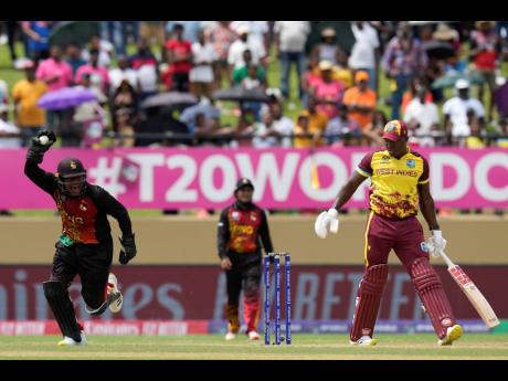 Papua New Guinea’s wicketkeeper Kipling Doriga celebrates taking the catch to dismiss West Indies captain Rovman Powell (right)  during an ICC Men’s T20 World Cup cricket match at Guyana National Stadium in Providence, Guyana, yesterday.