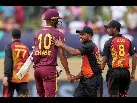 Papua New Guinea’s Sese Bau (right) congratulates West Indies batsman Roston Chase after their ICC Men’s T20 World Cup cricket match at Guyana National Stadium in Providence, Guyana, yesterday. Chase was the top-scorer for the West Indies with 42 not out.
