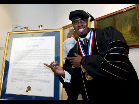 Credit: AP Entertainer Sean Combs poses next to his honorary degree of Doctor of Humanities during the graduation ceremony at Howard University in 2014.