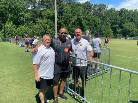 Credit: Contributed From left: Gerry Mouttet and Gary Peart, chairman Supreme Ventures Limited pose with head coach of the Reggae Rovers Marcelo Castillo in Cary North Carolina at the TST Soccer Tournament on Saturday.