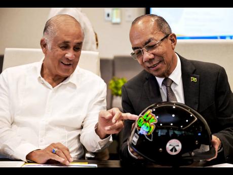 Minister of National Security, Dr Horace Chang (right), is in discussion with Chairman of the JN Foundation, Parris A. Lyew-Ayee, at the handover of 2,000 helmets donated by the Government, through the ministry, to the National Helmet Wearing Coalition (NHWC) on Wednesday. The presentation was made at the corporate offices of the Jamaica National Group on Oxford Road in St Andrew.