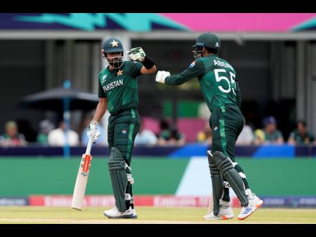 Pakistan’s Abbas Afridi (right) moves to touch gloves with captain Babar Azam as they bat during an ICC Men’s T20 World Cup cricket match against Ireland and Pakistan at the Central Broward Regional Park Stadium in Lauderhill, Florida, yesterday.
