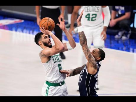 Boston Celtics forward Jayson Tatum (left) shoots over Dallas Mavericks forward P.J. Washington during the first half in Game 4 of the NBA basketball finals, Friday, June 14, 2024, in Dallas.