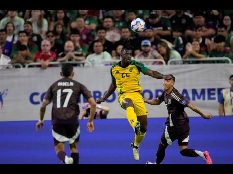 Credit: AP Jamaica’s Greg Leigh (22) heads the ball against Mexico during a Copa America Group B match in Houston, Saturday, June 22, 2024.