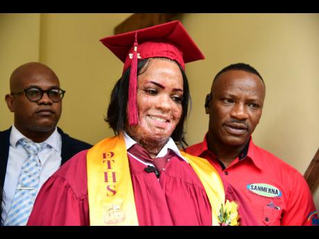 Alecia King smiles as she celebrates her graduation. Looking on are Stephen Josephs (left), project manager at Sanmerna Foundation and Robert White, managing director of the foundation.