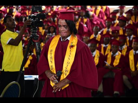 King makes the triumphant walk to collect her certificate during the Charlemont High School graduation ceremony held on Thursday at the Linstead Bread of Life Ministries in St Catherine.
