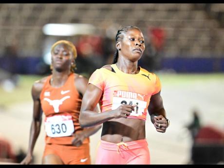 Defending national 100 metres champion Shericka Jackson (right) wins her heat in 10.99 seconds at the JAAA/Puma  National Junior and  Senior Championships at the National Stadium last night.