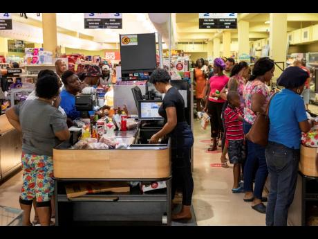 Costumers purchase groceries ahead of Hurricane Beryl in Arnos Vale, St Vincent and the Grenadines, yesterday. 
