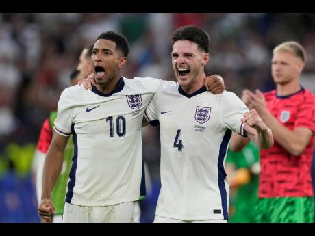 England’s Jude Bellingham (left) and teammate  Declan Rice celebrate at the end of the round of 16 match between England and Slovakia at the Euro 2024 tournament in Gelsenkirchen, Germany yesterday.
