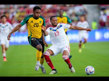 Jamaica’s Renaldo Cephas (left) and Venezuela’s Jose Martinez compete for possession during a Copa America Group B match between Jamaica and Venezuela in Austin, Texas yesterday. Venezuela won 3-0.