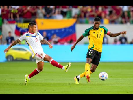 Jamaica’s Damion Lowe (right) passes the ball in front of Venezuela’s Darwin Machis during a Copa America Group B match between Jamaica and Venezuela, Sunday, June 30, 2024, in Austin, Texas. 