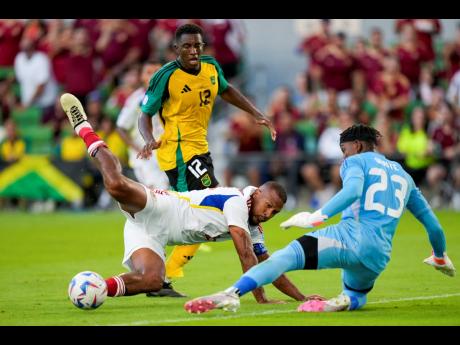 Venezuela’s Salomon Rondon (centre) gets a shot by Jamaica’s goalkeeper Jahmali Waite (right) to score his team’s second goal during a Copa America Group B match in Austin, Texas on June 30. Looking on is Jamaica’s Wesley Harding. 