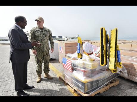 United States Ambassador to Jamaica, Nick Perry (left), and Lt Cmdr Zachary Smith, mission commander, Continuing Promise 2024, check some of the relief supplies.