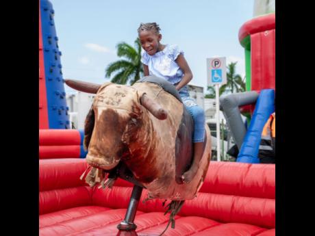 This little girl enjoys a ride at the amusement park section of the event.