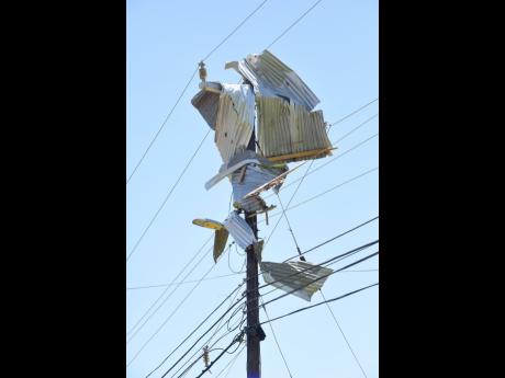 Sheets of zinc are wrapped around a utility pole.