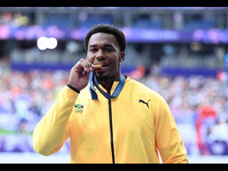 Credit: Gladstone Taylor Jamaica’s newly-minted men’s discus Olympic champion Roje Stona takes a bite of gold during the Paris Games medal ceremony at the Stade de France in Paris yesterday. Stona broke the Olympic Games record to become the first ever Jamaican to win the event at the Olympic Games.