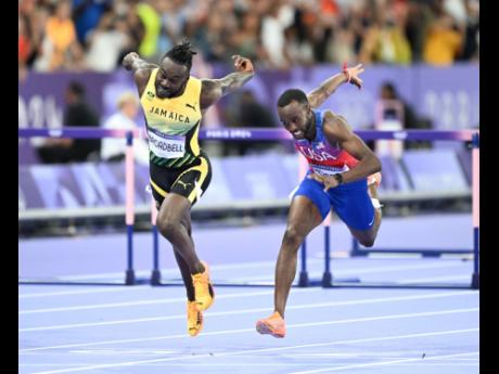 Credit: Gladstone Taylor Jamaica’s Rasheed Broadbell (left) and Daniel Roberts of the United States dip for the finish line in the men’s 110m hurdles final at the Stade de France in Paris, Saint-Denis, France yesterday. The United States’ Grant Holloway (out of photo) won, while Roberts out-dipped Broadbell for silver.