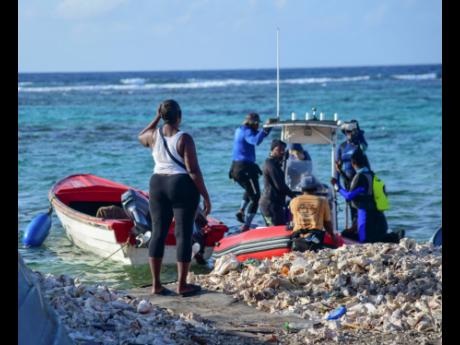 Credit: Antoine Lodge/Photographer A woman looks on as divers board a boat on the Pedro Cays on August 10.