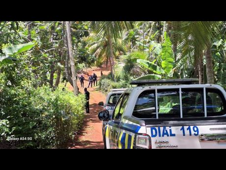 Credit: Almando Smith Police personnel on the scene in Cudjoe Hill, St Catherine where a wake for an elderly resident was shot up by gunmen early Wednesday morning.
