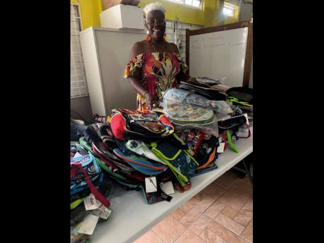 Credit: Tiffany Taylor Novelette Edwards-Tomlinson with some of the back-to-school supplies she was giving away at her annual treat last Friday.