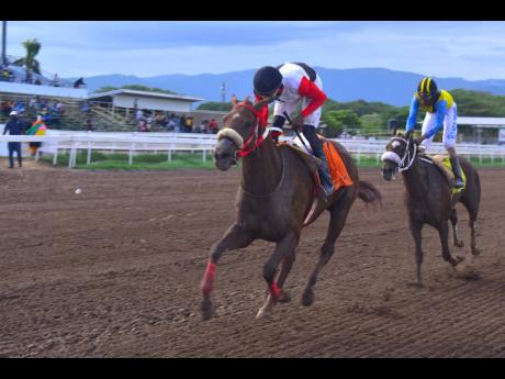 MONEY MISER (left), ridden by Tevin Foster, wins the O & S Tack Room Trophy Division I over a mile at Caymanas Park on Saturday.