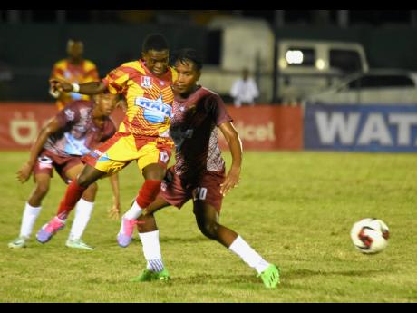 Credit: Ashley Anguin Cornwall College’s Miguel Arnold (second right) tries to claim possession before Herbert Morrison Technical’s Ranaldo Blackwood (right) during the opening match of ISSA/WATA daCosta Cup football competition at Montego Bay Sports Complex on Saturday. Cornwall College won 4-1.