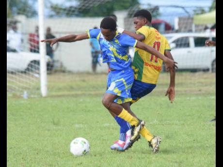 Cambridge High School’s Jayr Moore (left) and Rusea’s High’s Maliek Headed challenge for the ball during their ISSA/WATA daCosta Cup football match at Collin Miller Sports Complex in Lucea, Hanover, on Tuesday. Rusea’s High won 3-1.