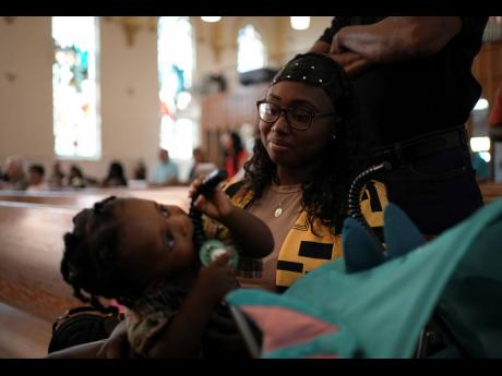 Parishioner Rose Carmelle Bellevue looks at her one-year-old son during a service at St Raphael Catholic Church in Springfield, Ohio.