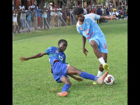 St George’s College’s Tae-Sean Oneil (right) tries to evade the sliding challenge of Demarco Hunter during their Manning Cup encounter at Winchester Park yesterday.