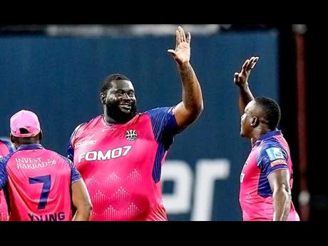 Rahkeem Cornwall (centre) celebrates with the Barbados Royals’ skipper Rovman Powell after claiming a wicket against the St Kitts & Nevis Patriots during the Caribbean Premier League T20 cricket competition at Kensington Oval on Tuesday night. Cornwall took 5-16.