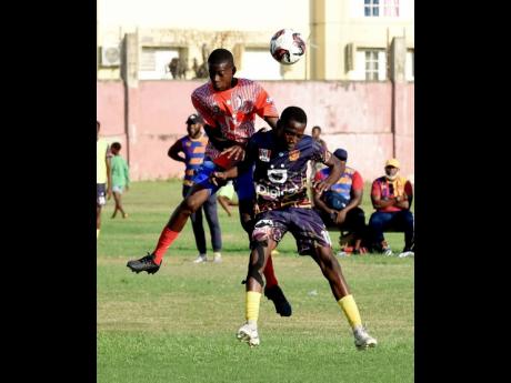 Credit: Ian Allen Jahreem McKenzie (left) of Camperdown High School and Kennardo Gordon of St Andrew Technical High School (STATHS) are caught in an aerial battle for the ball during their ISSA/WATA Manning Cup football match at Boys’ Town yesterday. STATHS won 2-0.