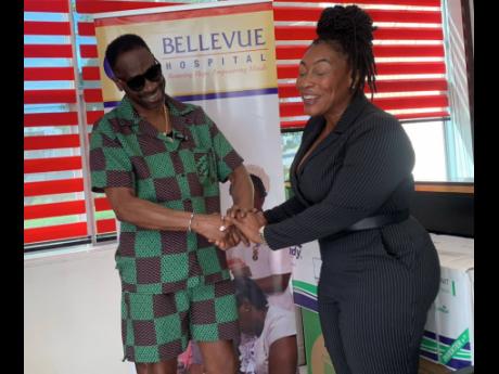 Credit: Natasha Williams Bounty Killer shared a moment of laughter with Bellevue CEO Suzette Buchanan, during the handover of the items, including air conditioning units, wheelchairs and walkers, that the hospital received from the Bounty Foundation on Thursday.