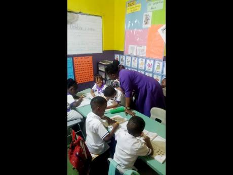 Credit: Tiffany Pryce A teacher at Nadz Kidz World helping students with their lessons.