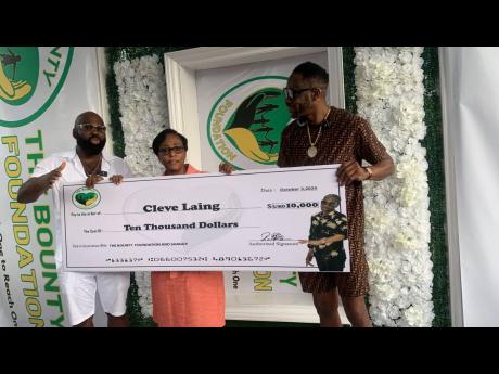 Credit: Natasha Williams From left: Reggae-dancehall singer Richie Stephens along with Stitchie’s wife, Sophia Laing, look on as Bounty Killer presents her with a cheque of $US10,000 courtesy of the Bounty Foundation and Shaggy, towards the medical expenses for the veteran gospel-reggae singjay.