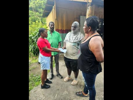 Credit: Contributed Sashenee Ogilvie (left), friend of Omar Skyers, who drowned while on a river excursion last month, presents money to (from second left) Steven Hilton, Owain Stephenson and Georgia Phillips in gratitude for their fervent search to find him.