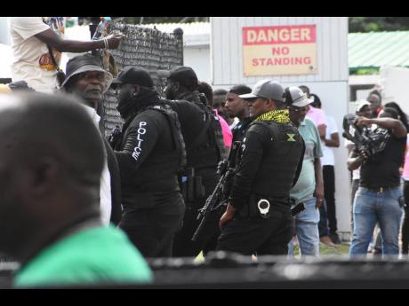 Police personnel marshall an area of the racetrack after disgruntled punters protesting the disqualification of Samantha Fletcher’s mount, first-past-the-post TEKAPUNT, and handed the second event to Raddesh Roman astride SALUD, at Caymanas Park yesterday.