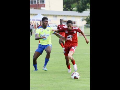 Glenmuir High School’s Dunsting Cohen (right) dribbles away from Clarendon College’s Ronaldo Williams during their ISSA/WATA daCosta Cup football match at Glenmuir High School on October 17. Cohen scored in the 47th and 92nd minutes as Glenmuir won 2-0.