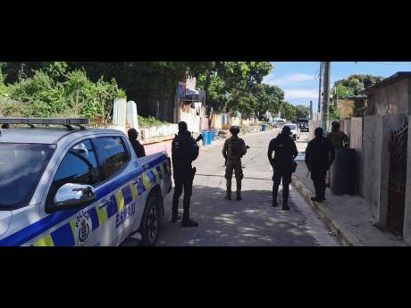 Police at the scene of a deadly shooting that claimed five lives in Rockfort, east Kingston, on Monday night. 