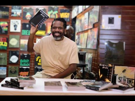 Credit: Contributed Author ‘Squidell’ shows off his first published book, Essential Notes: A Glimpse into the Reality of the Music Industry, at his book signing and meet and greet session in Jamaica recently.