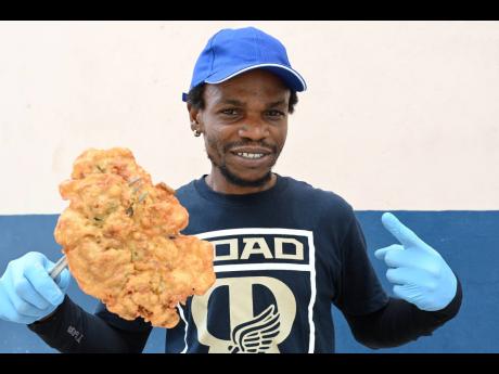 Credit: Rudolph Brown Photos Andrew Burke shows off one of his famous salt fish fritters.