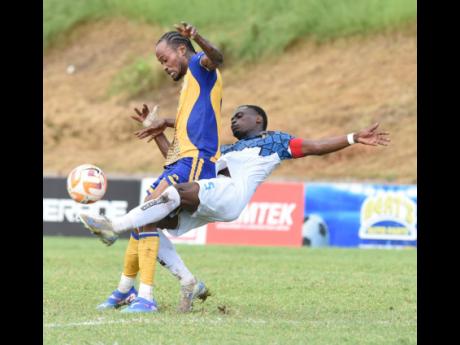 Credit: Ian Allen Andre Fagan of Harbour View Football Club gets a foul tackle from behind by Romaine Bowers of Racing United Football Club during their Jamaica Premier League football match at Stadium East yesterday. Harbour View won 3-1.