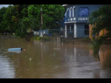 Credit: Ian Allen Floodwaters flowed into homes, again, in Nightingale Grove, Gutters, St Catherine, yesterday as Tropical Storm Rafael brought plenty of rain.